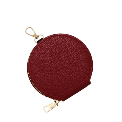Round red coin purse with gold zipper on a white background