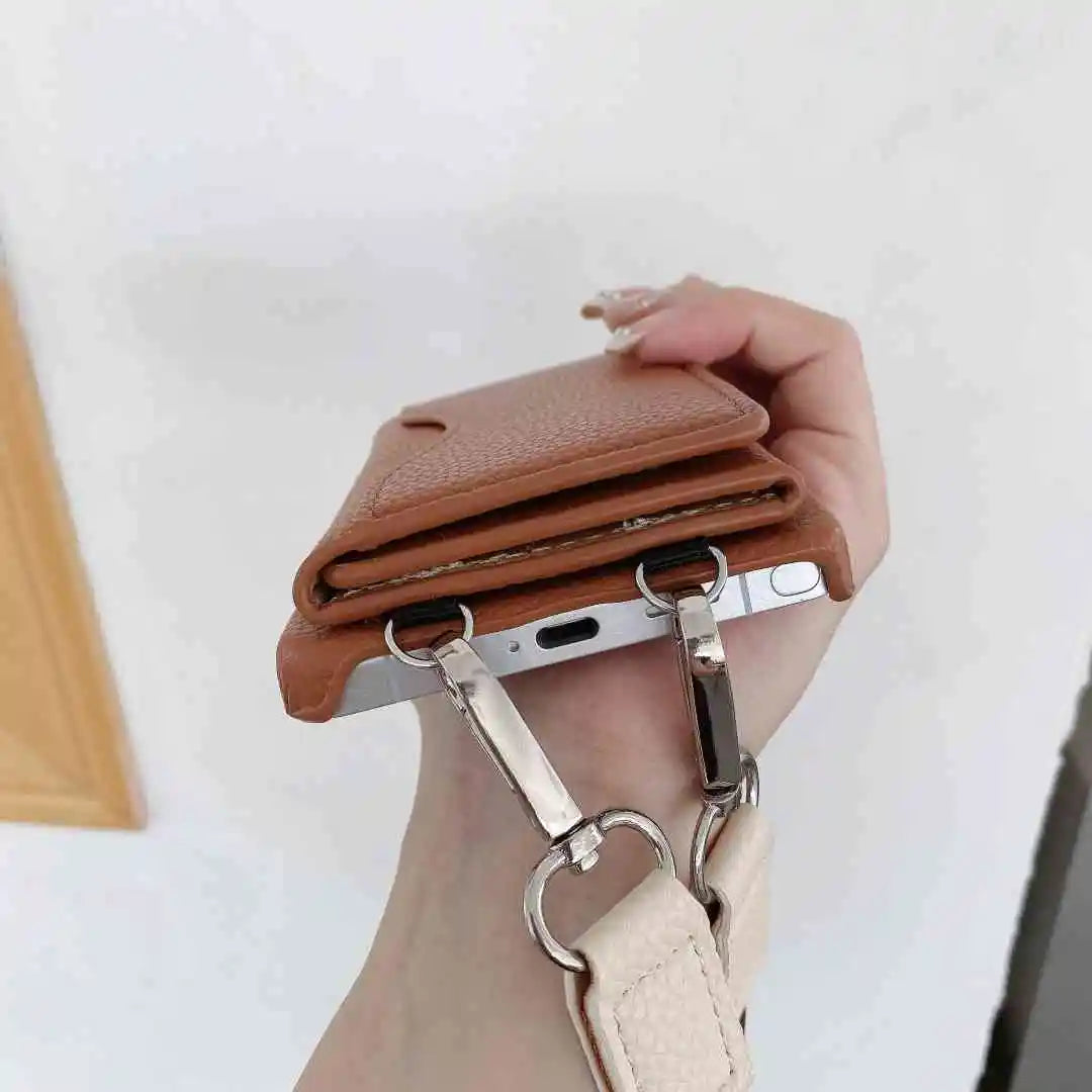 Brown leather wallet with keychain attached, held by a hand against a white background