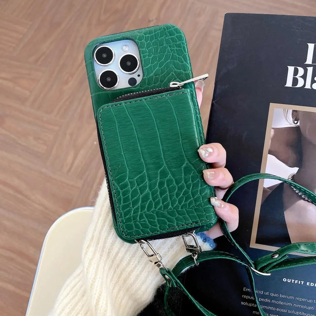 Green crocodile-patterned phone case held by a hand with a blurred magazine in the background