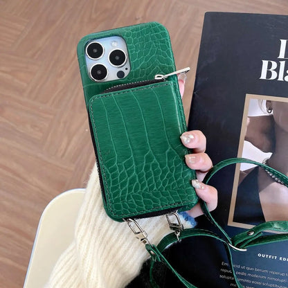 Green crocodile-patterned phone case held by a hand with a blurred magazine in the background
