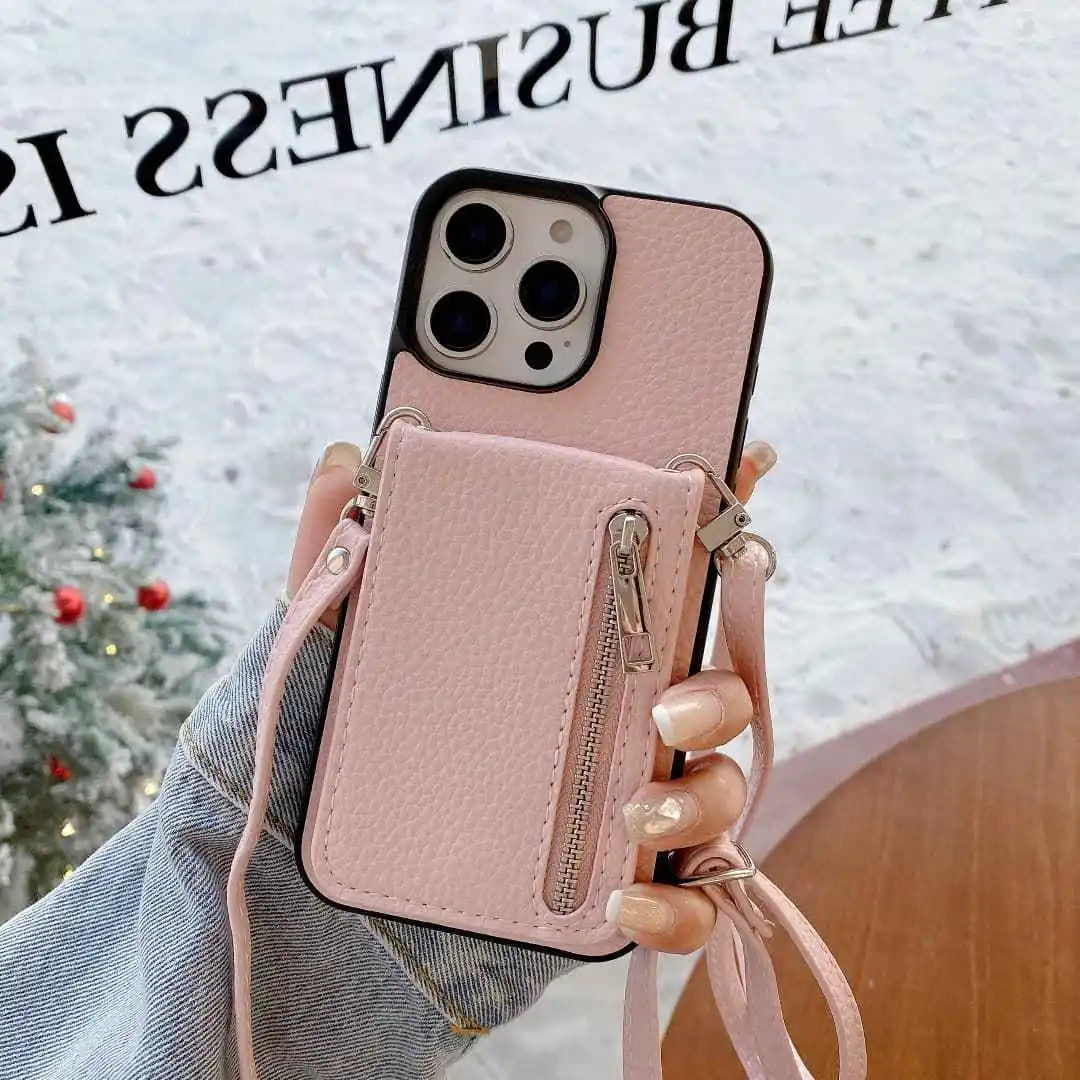 Pink leather phone case with card holder and strap held by a hand against a blurred background