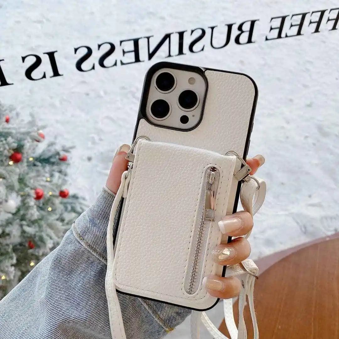 white leather Phone case with card holder and strap held by a hand, Christmas tree in the background