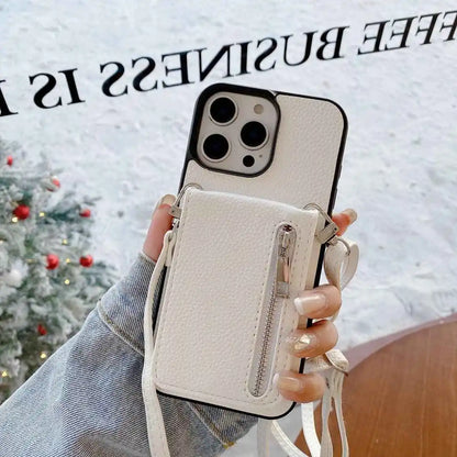 white leather Phone case with card holder and strap held by a hand, Christmas tree in the background