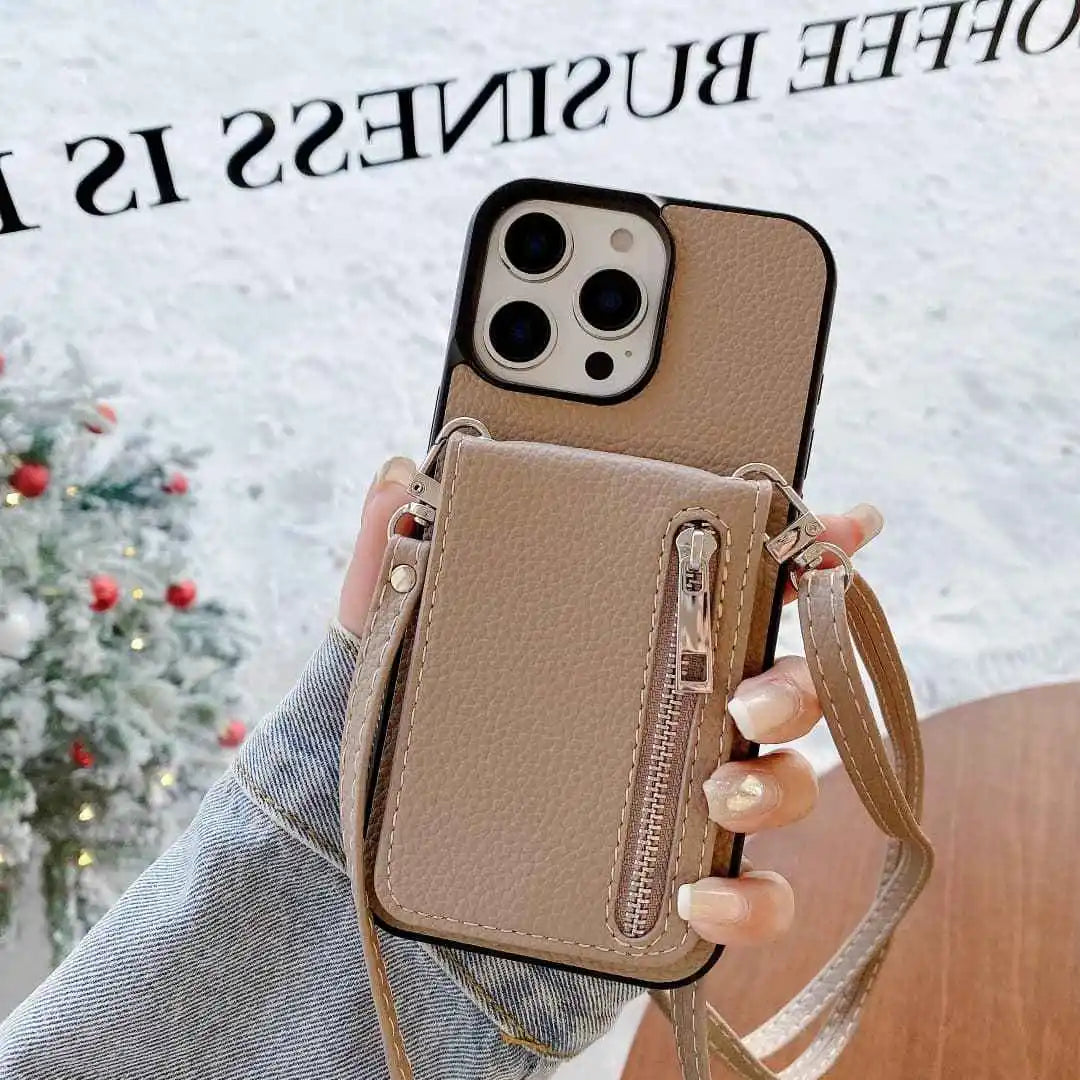 Tan Phone case with a detachable strap held by a hand against a blurred Christmas tree background