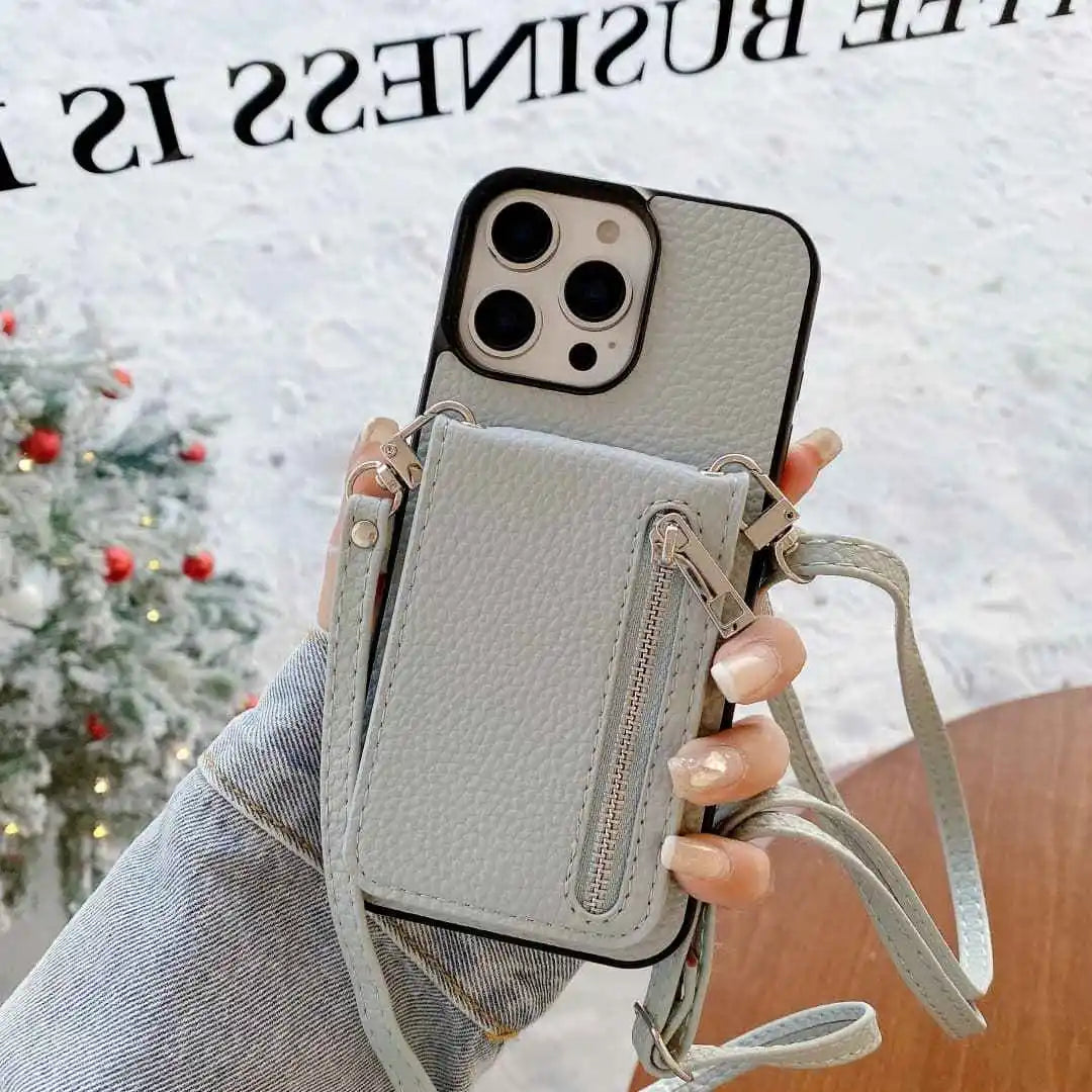 dusty blue Phone case with wallet and crossbody strap held by a hand, Christmas tree in the background