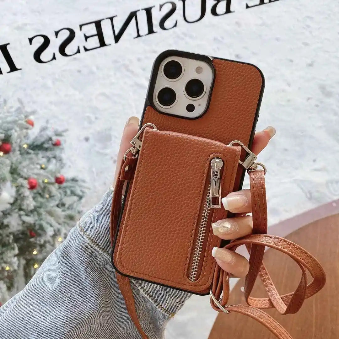 Brown phone case with card holder and strap held by a hand, Christmas tree in the background