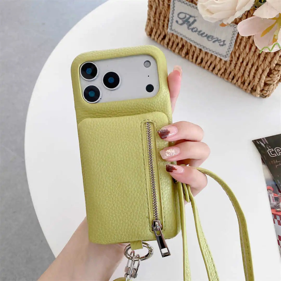 Hand holding a lime green phone case with a zipper wallet and strap, on a white surface with a floral arrangement.