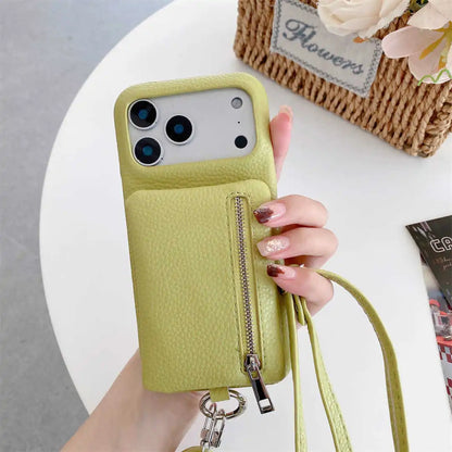 Hand holding a lime green phone case with a zipper wallet and strap, on a white surface with a floral arrangement.