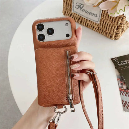 Brown leather phone case with a zipper wallet and strap held by a hand on a light background