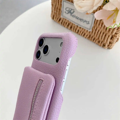 Purple phone case with a zipper wallet on a white surface with flowers in the background