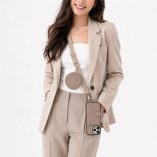 Woman wearing a beige blazer and pants with a matching crossbody wallet phone combo on a white background