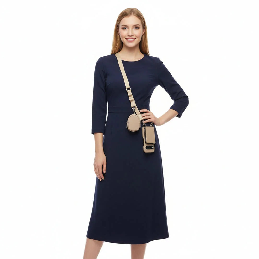 Woman wearing a navy dress with a beige crossbody wallet phone set on a white background