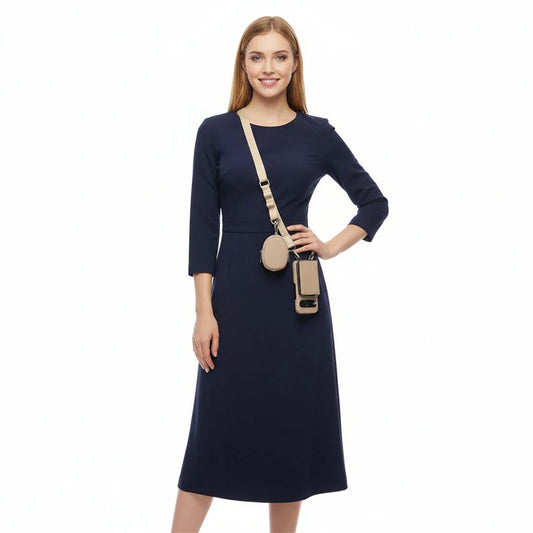 Woman wearing a navy dress with a beige crossbody wallet phone set on a white background