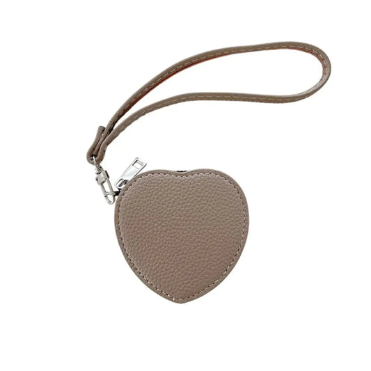 Heart-shaped tan pouch with a strap on a white background