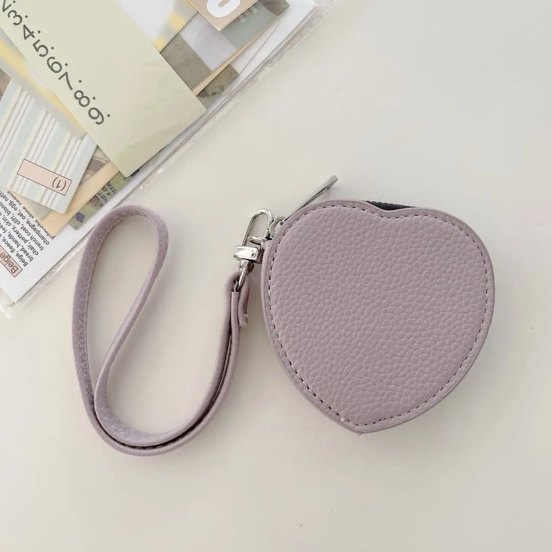Heart-shaped purple pouch with a strap on a light surface