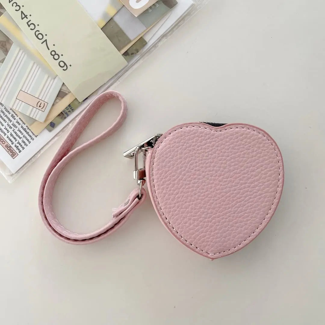 Heart-shaped pink pouch with a strap on a light surface