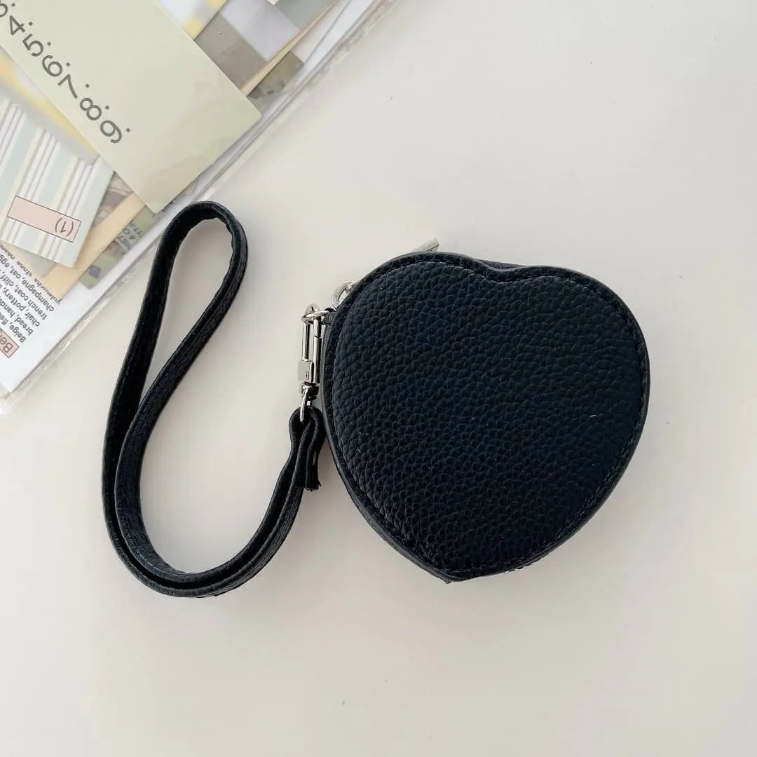 Black heart-shaped pouch with a strap on a light gray background