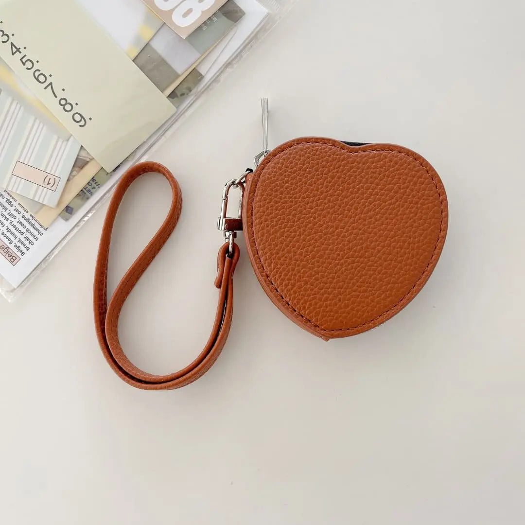 Brown heart-shaped pouch with a strap on a light surface