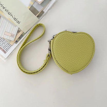 Heart-shaped lime green pouch with a strap on a light gray background