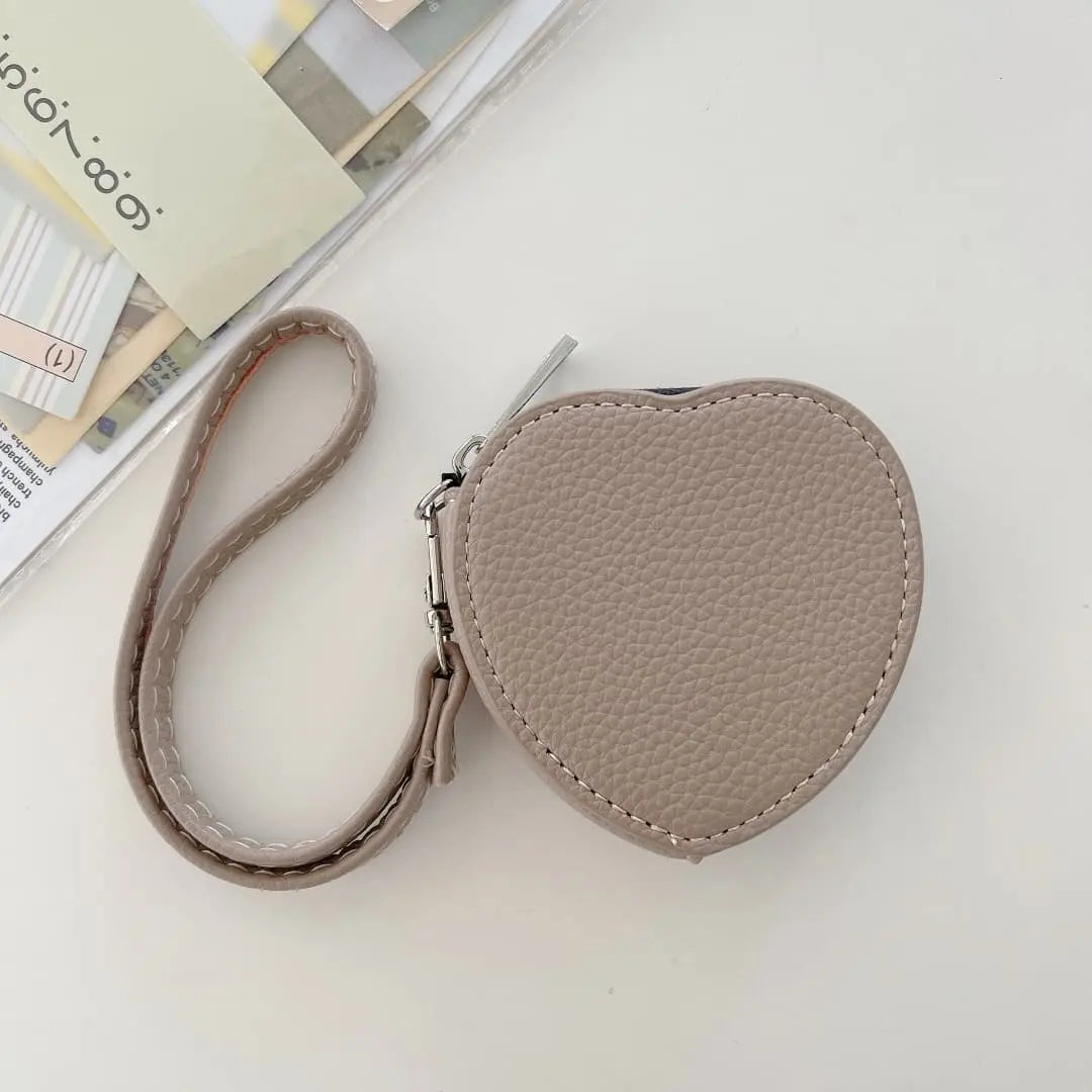 Heart-shaped pouch with a strap on a light surface