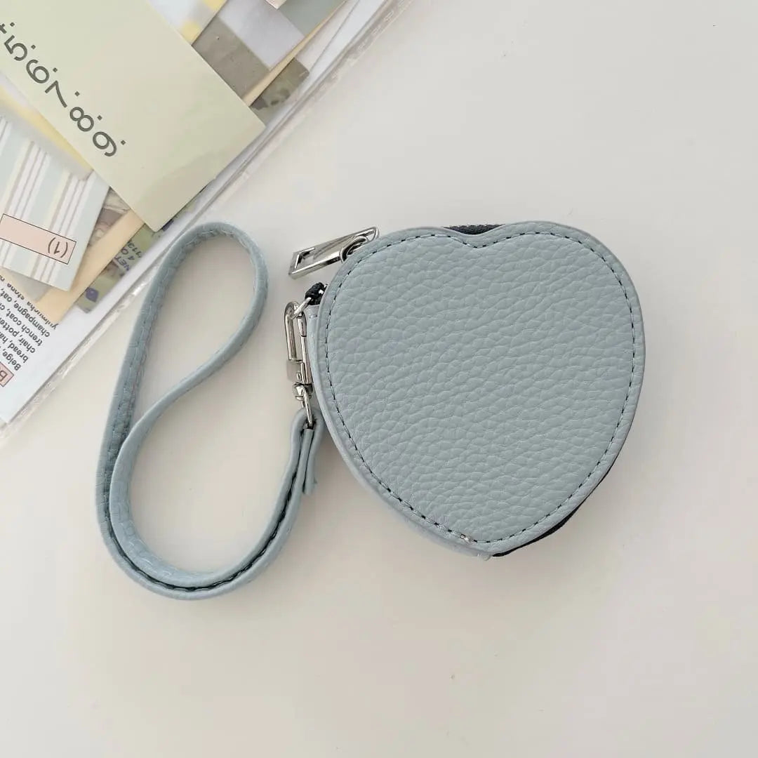 Heart-shaped keychain pouch with strap on a light surface