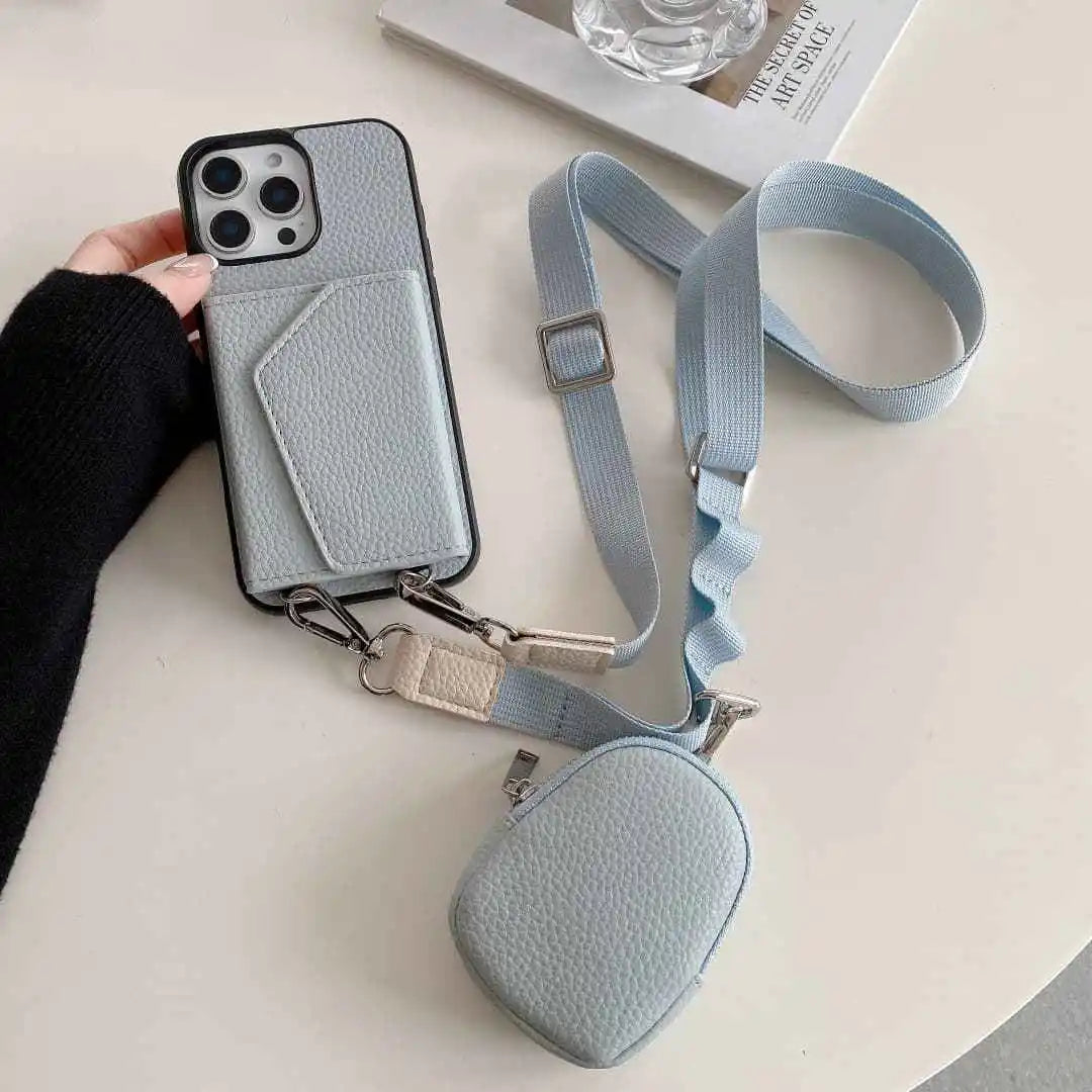 Dusty blue wallet phone case with a detachable strap on a light surface.
