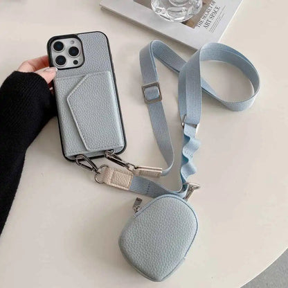Dusty blue wallet phone case with a detachable strap on a light surface.