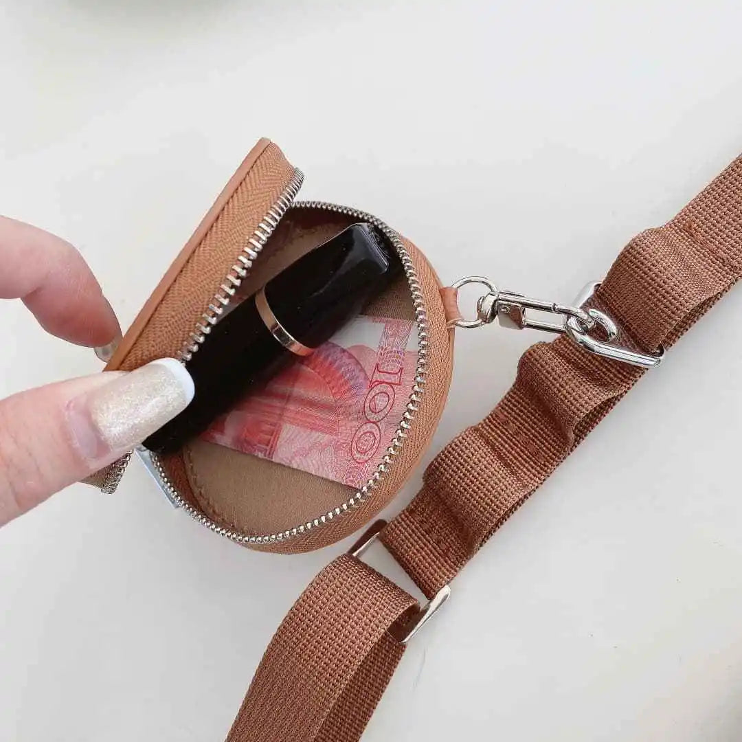 Brown pouch with a strap, containing a phone and money, on a white background