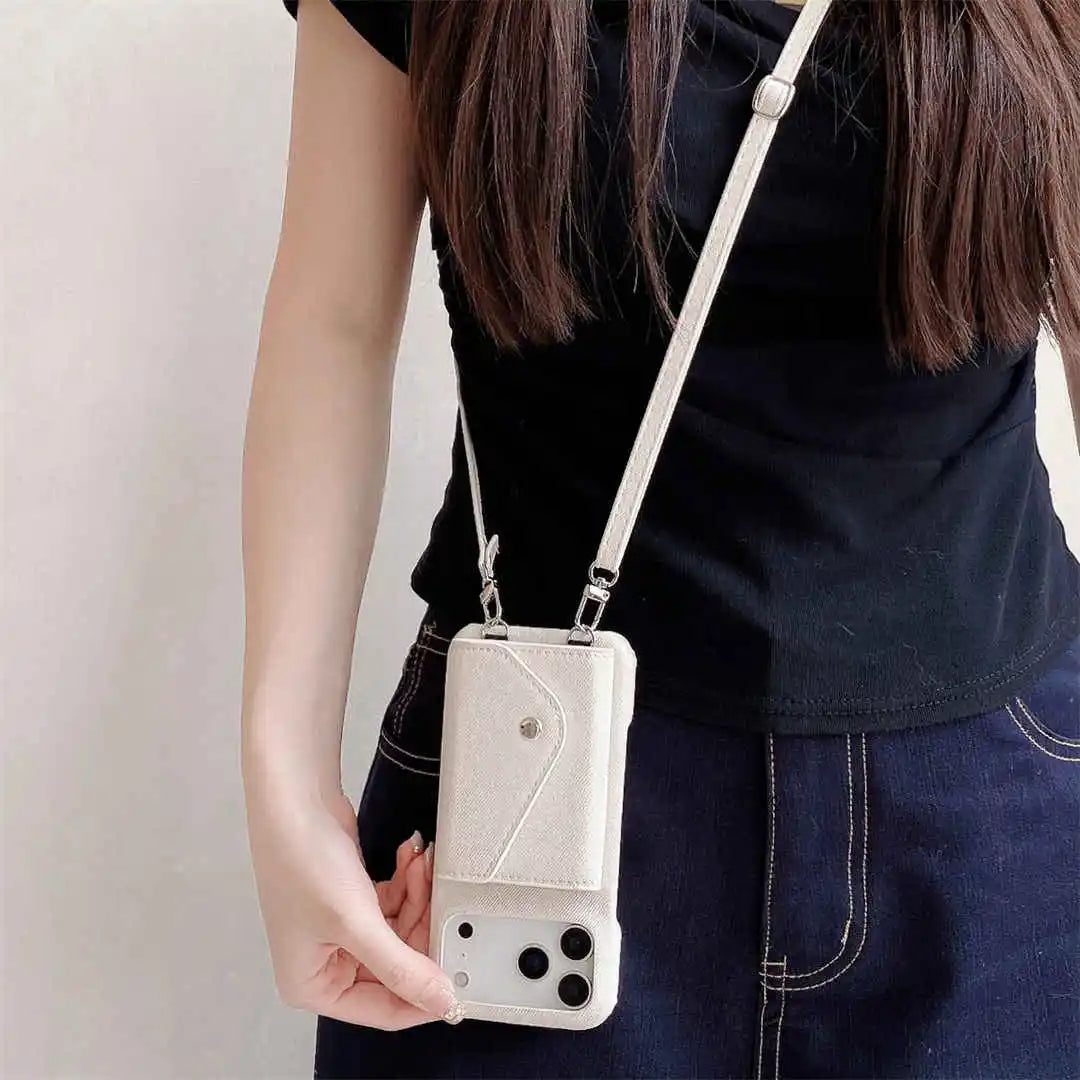 Person holding a beige crossbody purse with a phone case attached against a plain background
