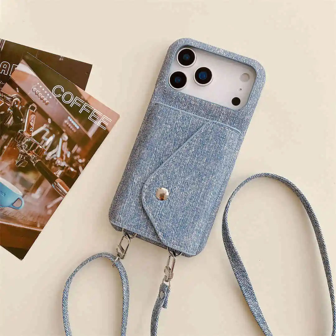 Blue denim phone case with a strap on a beige surface