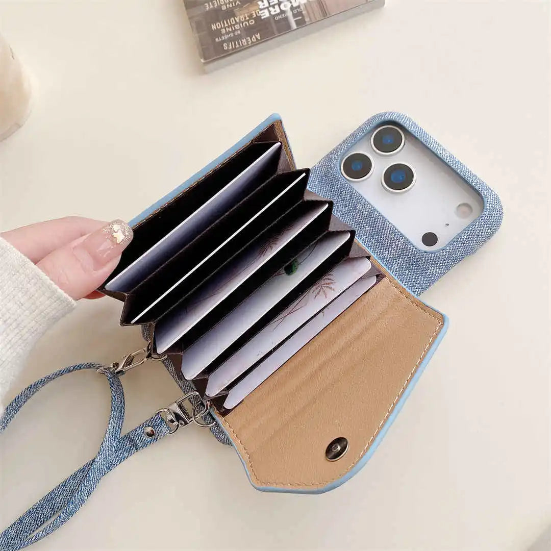 Blue denim wallet phone case with 6 card holders and strap on a light surface