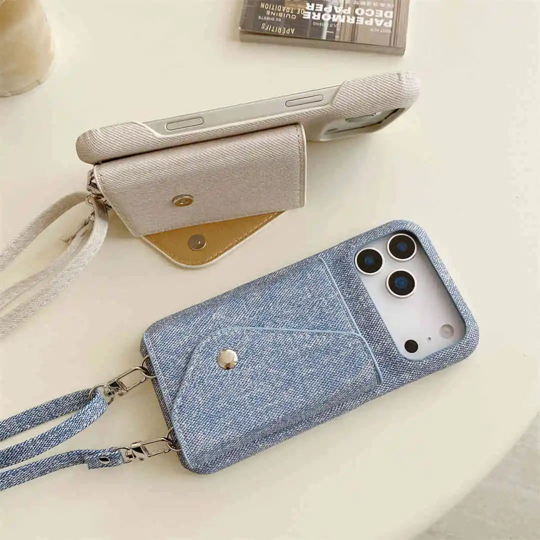 Blue denim phone case with a wallet and strap on a light surface