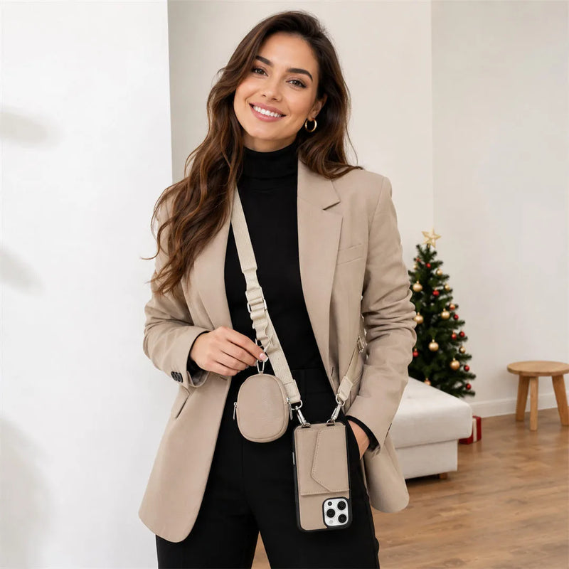 Woman in a beige blazer holding a matching crossbody wallet combo in a room with a Christmas tree.