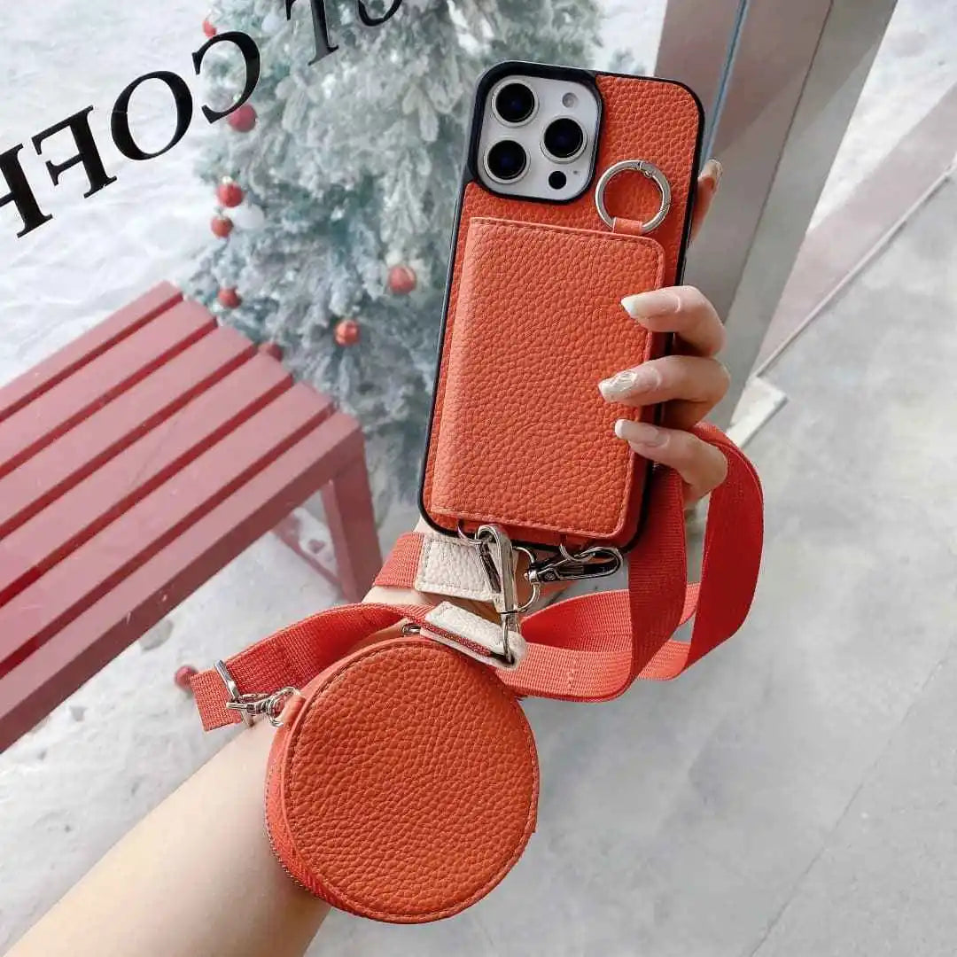 Orange wallet phone case with detachable strap held by a hand, blurred background