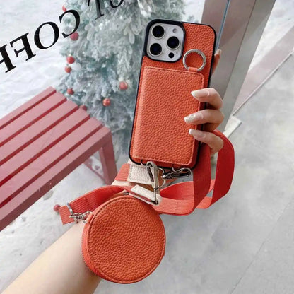 Orange wallet phone case with detachable strap held by a hand, blurred background