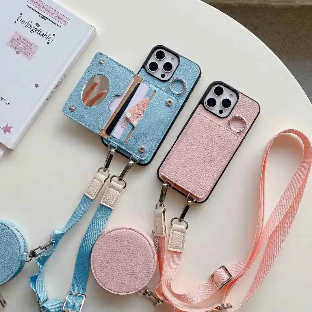 Two wallet phone cases with straps, one blue and one pink, on a light surface.
