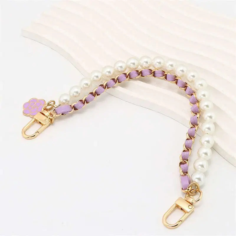 Pearl and purple beaded bag strap with gold hardware on a white background