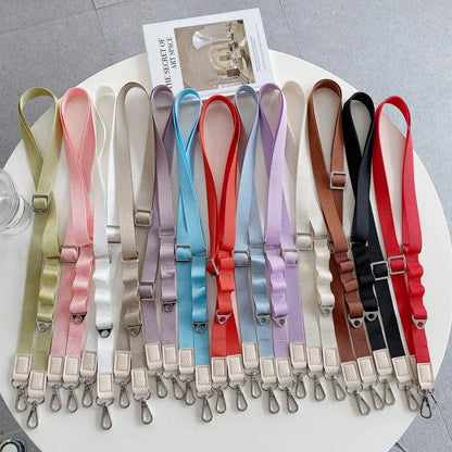 Set of colorful phone crossbody straps on a white surface with a gray background