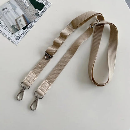 taupe crossbody strap with metal clasps on a light gray background