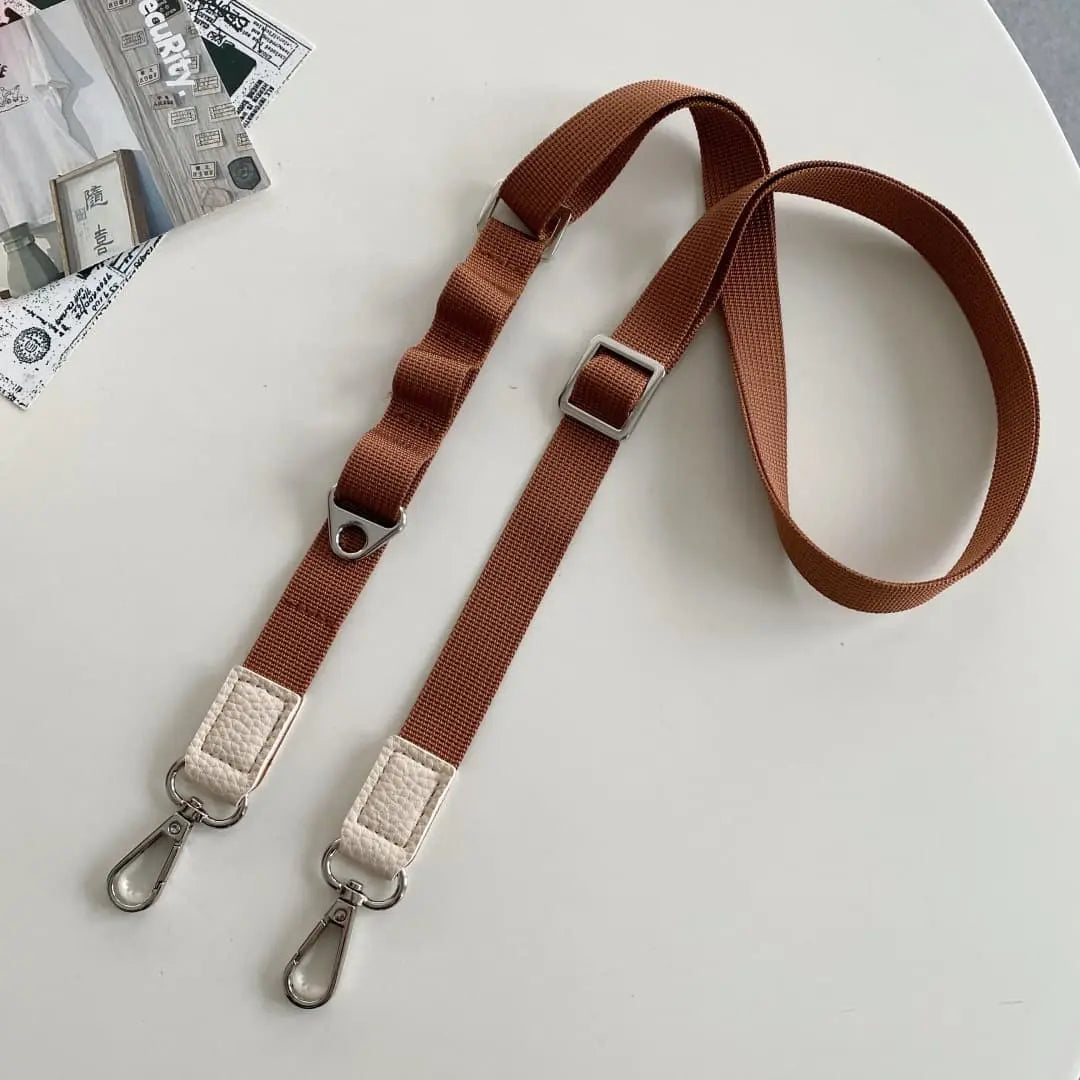 Brown cell phone strap with metal clasps on a light gray background