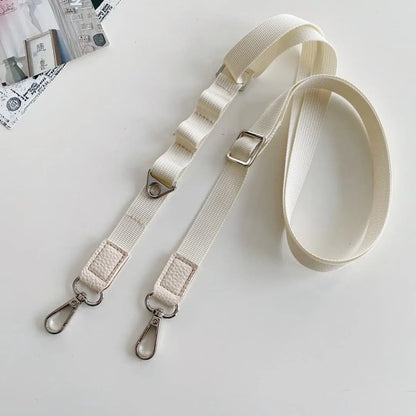 Beige crossbody strap with metal clasps on a light gray background