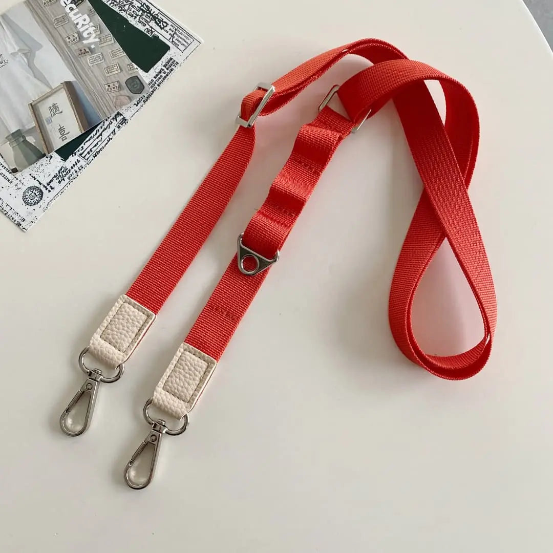orange nylon phone strap with silver hardware on a white background