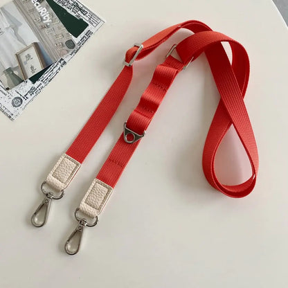 orange nylon phone strap with silver hardware on a white background